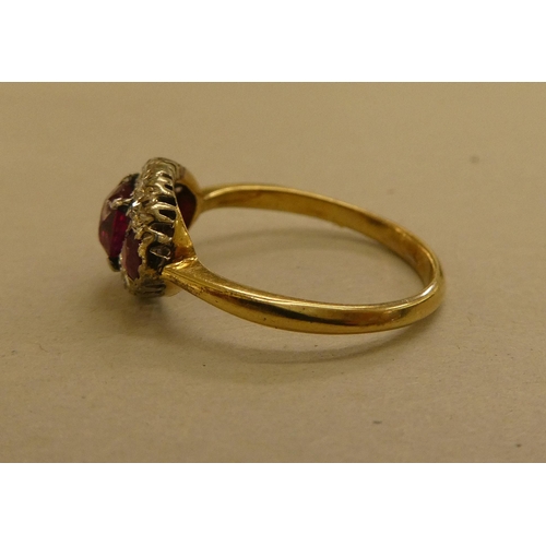 320 - A yellow metal ring, set with diamonds and red stones