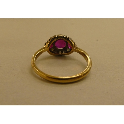 320 - A yellow metal ring, set with diamonds and red stones