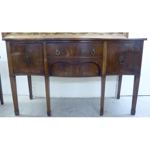 42 - An early 20thC Georgian design mahogany serpentine front serving sideboard with two central drawers,... 