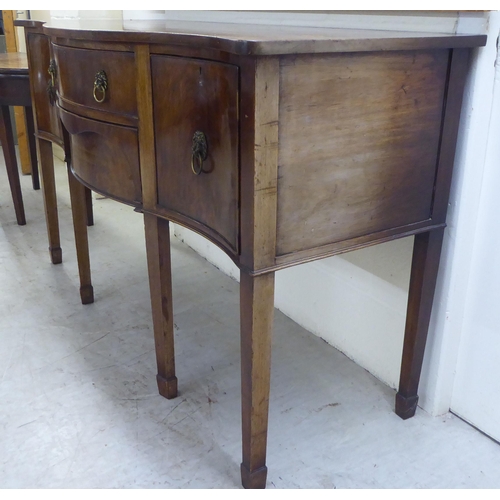 42 - An early 20thC Georgian design mahogany serpentine front serving sideboard with two central drawers,... 