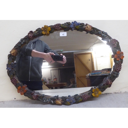 47 - An early 20thC barbola mirror, the bevelled oval plate set in a painted plaster frame  18