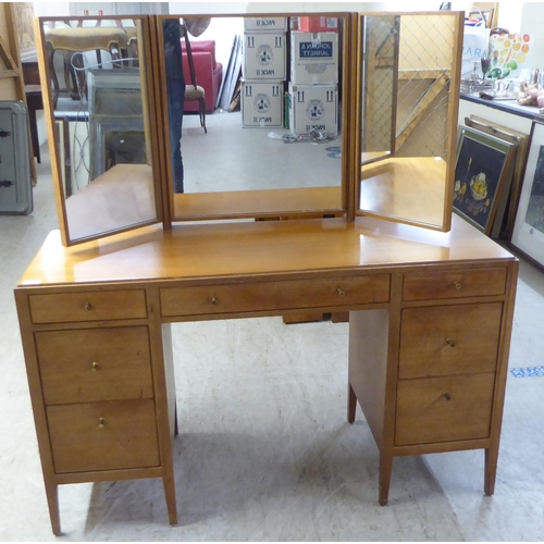 48 - A 1960s/1970s bleached mahogany seven drawer dressing table, surmounted by a triptych mirror  5... 