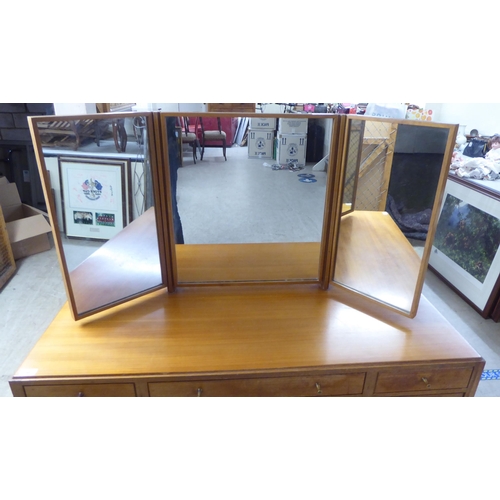 48 - A 1960s/1970s bleached mahogany seven drawer dressing table, surmounted by a triptych mirror  5... 