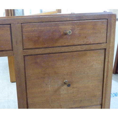 48 - A 1960s/1970s bleached mahogany seven drawer dressing table, surmounted by a triptych mirror  5... 