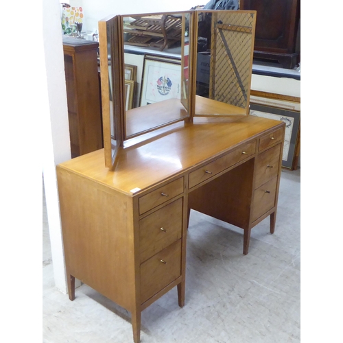 48 - A 1960s/1970s bleached mahogany seven drawer dressing table, surmounted by a triptych mirror  5... 