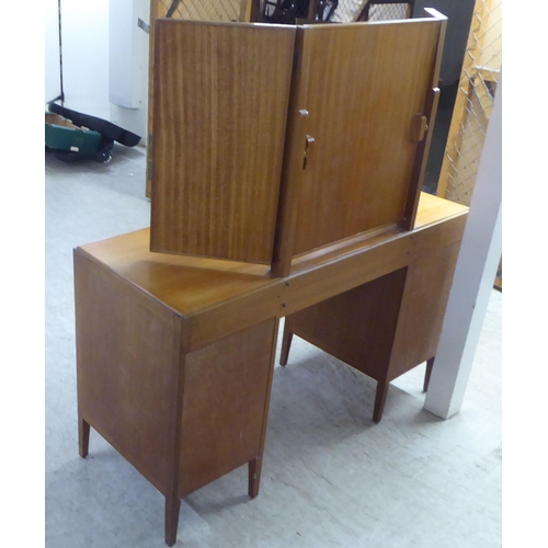 48 - A 1960s/1970s bleached mahogany seven drawer dressing table, surmounted by a triptych mirror  5... 