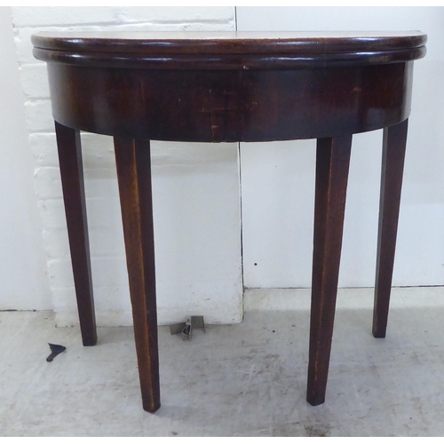 51 - A George III mahogany demi-lune tea table, the hinged top raised on square, tapered legs  28