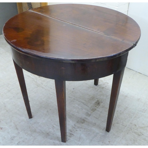 51 - A George III mahogany demi-lune tea table, the hinged top raised on square, tapered legs  28