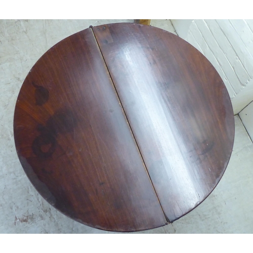 51 - A George III mahogany demi-lune tea table, the hinged top raised on square, tapered legs  28