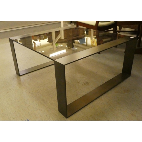 59 - A modern burnished bronze coloured, steel framed coffee table with smoked glass top  17