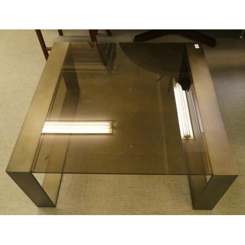 59 - A modern burnished bronze coloured, steel framed coffee table with smoked glass top  17