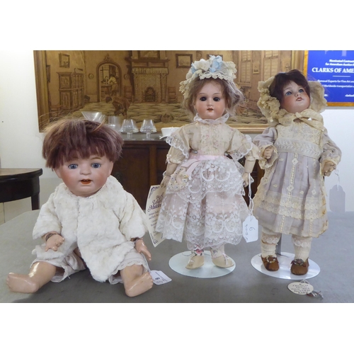 6 - Three bisque head dolls: to include an early 20thC example with painted features, on a jointed compo... 