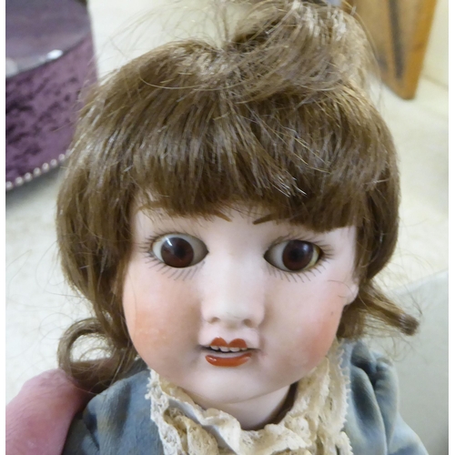 7 - Dolls: to include an early 20thC Armand Marseille bisque head example with painted features, on a jo... 