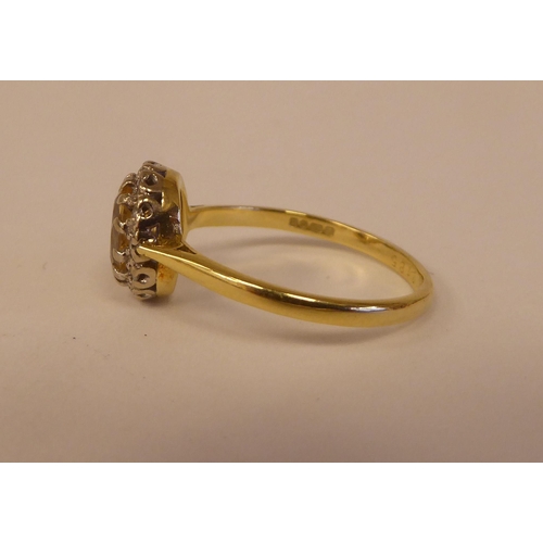 80 - An 18ct bi-coloured gold ring, set with a central yellow stone, surrounded by small diamonds