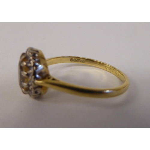 80 - An 18ct bi-coloured gold ring, set with a central yellow stone, surrounded by small diamonds