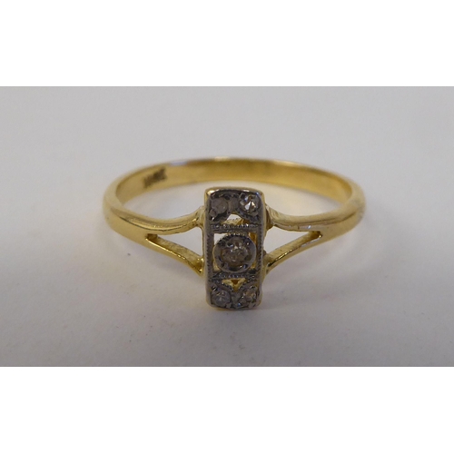 85 - A yellow metal ring, set with five diamonds, arranged on a central bar  stamped 18ct 