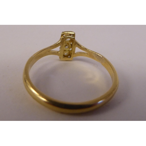 85 - A yellow metal ring, set with five diamonds, arranged on a central bar  stamped 18ct 