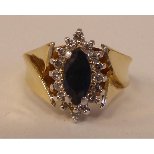 90 - A 14ct gold ring, set with a sapphire and diamond, surrounded by small claw set diamonds