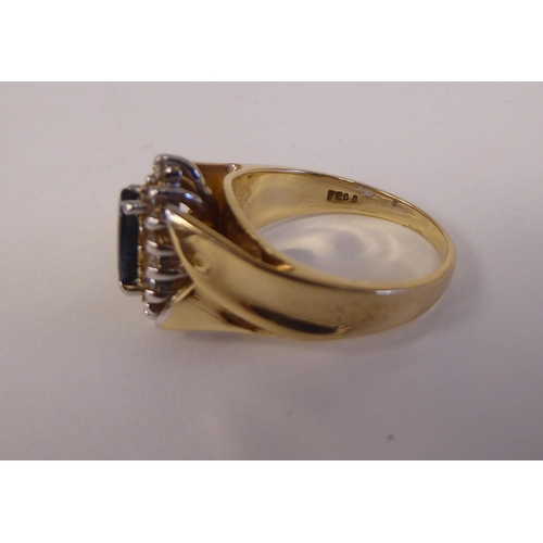 90 - A 14ct gold ring, set with a sapphire and diamond, surrounded by small claw set diamonds