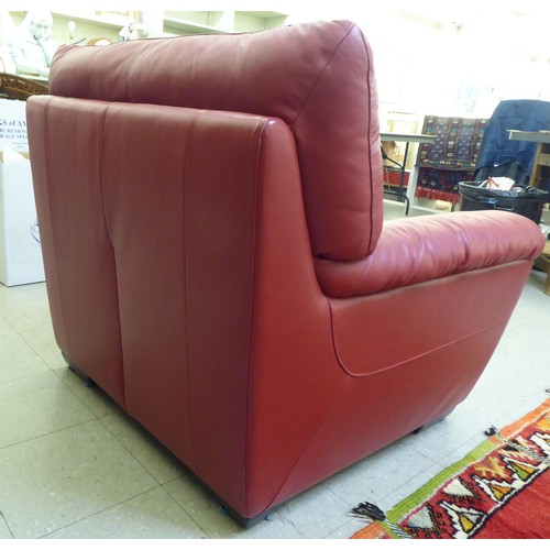 224 - A modern red faux hide upholstered armchair