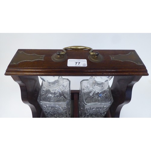 77 - A modern oak tantalus, accompanied by two glass decanters  12.5