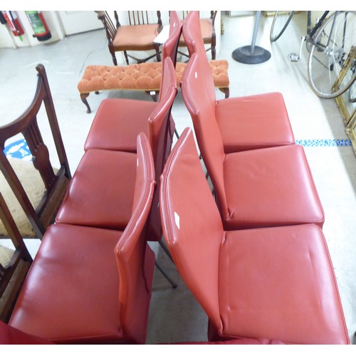 239 - A set of six modern red faux hide upholstered dining chairs, raised on splayed metal legs