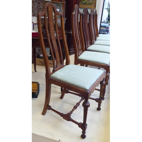 18 - A set of six early 20thC oak framed dining chairs, the fabric upholstered drop-in seats raised on tu... 