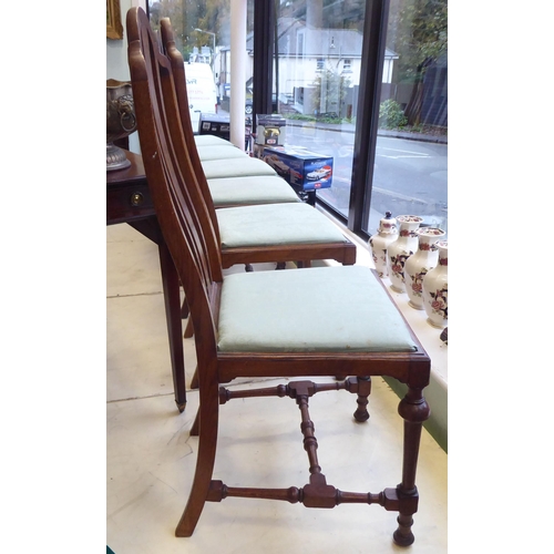 18 - A set of six early 20thC oak framed dining chairs, the fabric upholstered drop-in seats raised on tu... 