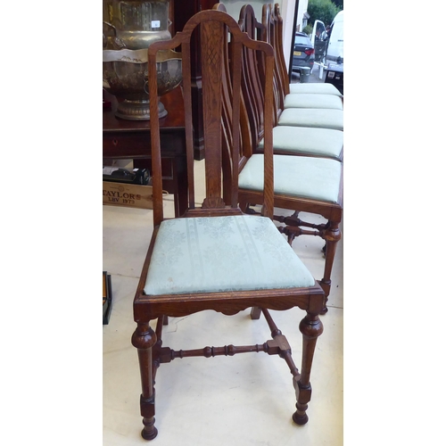 18 - A set of six early 20thC oak framed dining chairs, the fabric upholstered drop-in seats raised on tu... 