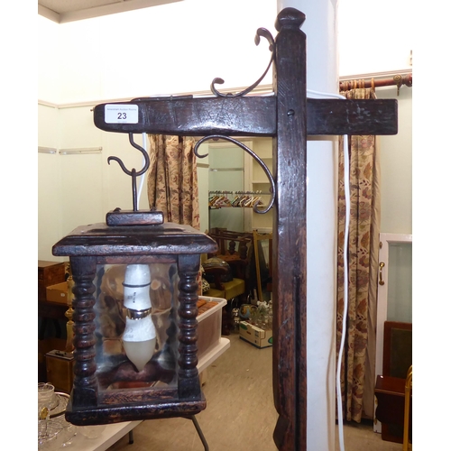 23 - An early 20thC traditional English style oak standard lamp with wrought iron mounts with a lantern p... 