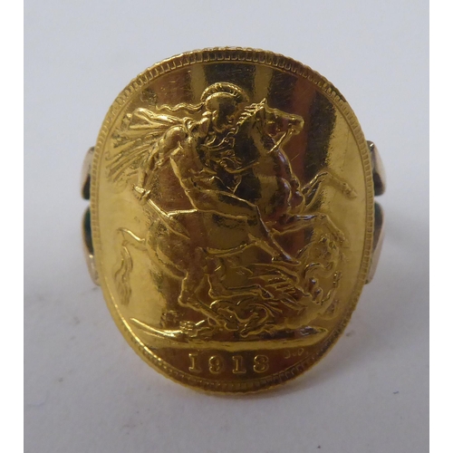 266 - A gold coloured metal signet ring, incorporating a George V sovereign, St George on the obverse  191... 