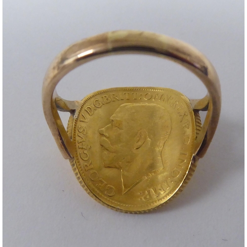 266 - A gold coloured metal signet ring, incorporating a George V sovereign, St George on the obverse  191... 