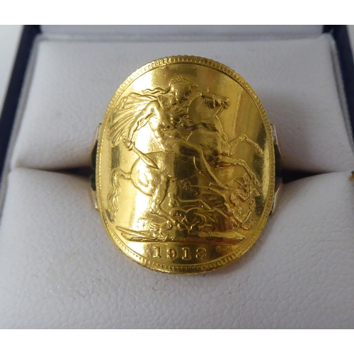 266 - A gold coloured metal signet ring, incorporating a George V sovereign, St George on the obverse  191... 