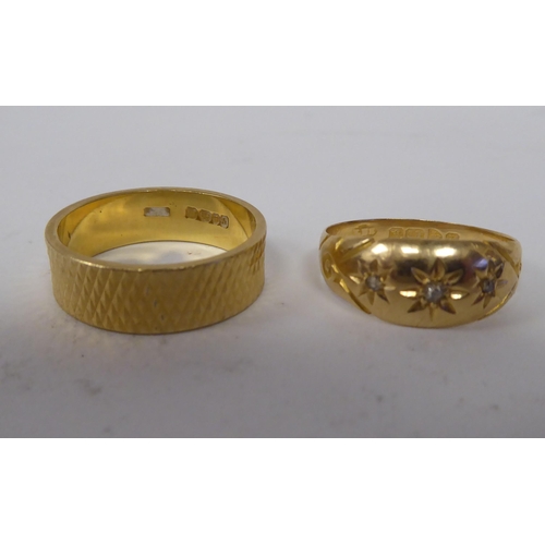 272 - An 18ct gold rubover set, three diamond ring; and an 18ct gold, textured band ring