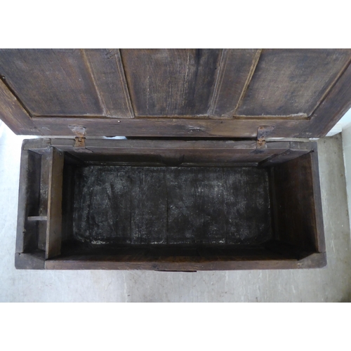 28 - An early 18thC oak coffer with straight sides and a hinged lid, on block feet  22