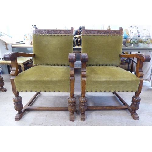 29 - A set of six 1920s carved oak framed dining chairs with green fabric stud upholstered, cushioned bac... 