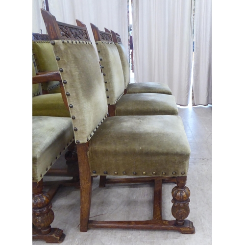 29 - A set of six 1920s carved oak framed dining chairs with green fabric stud upholstered, cushioned bac... 