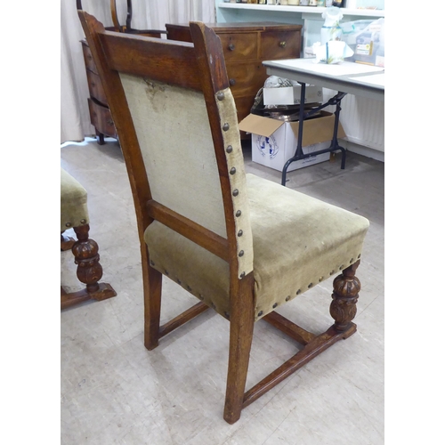 29 - A set of six 1920s carved oak framed dining chairs with green fabric stud upholstered, cushioned bac... 