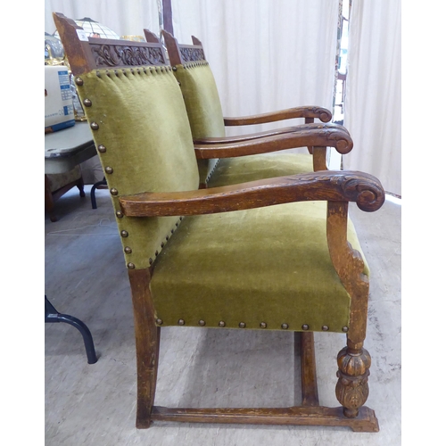 29 - A set of six 1920s carved oak framed dining chairs with green fabric stud upholstered, cushioned bac... 