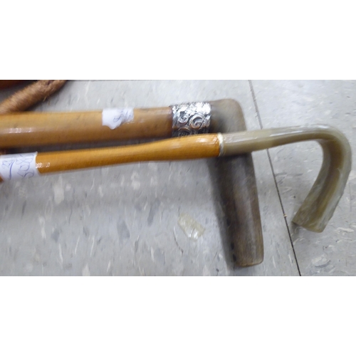 326 - Five walking aids: to include a Malacca cane with a silver ferrule