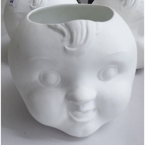 44 - Interior design accessories: to include four china tea light holders, fashioned as children's faces ... 