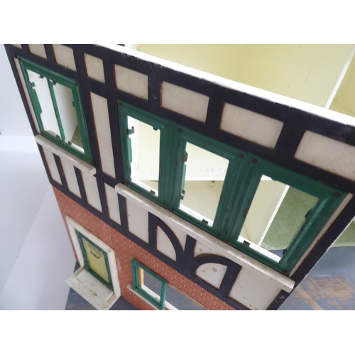 47 - A 20thC scratch built doll's house, fashioned as a faux brick Tudor inspired home with front hinged ... 