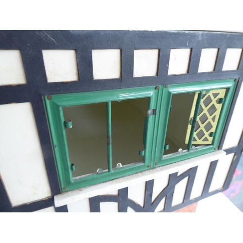 47 - A 20thC scratch built doll's house, fashioned as a faux brick Tudor inspired home with front hinged ... 