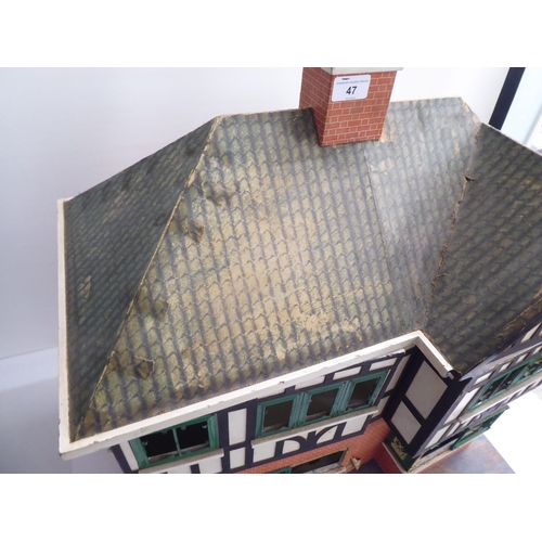 47 - A 20thC scratch built doll's house, fashioned as a faux brick Tudor inspired home with front hinged ... 