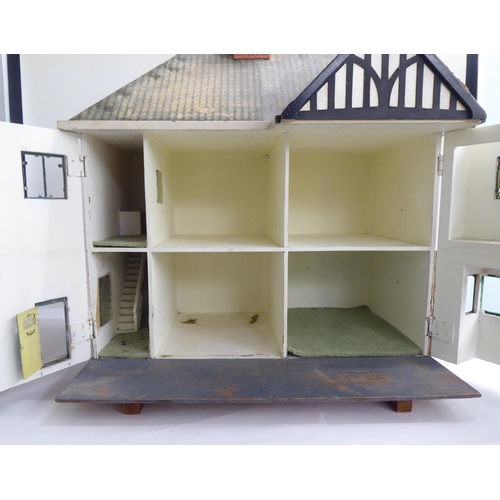 47 - A 20thC scratch built doll's house, fashioned as a faux brick Tudor inspired home with front hinged ... 