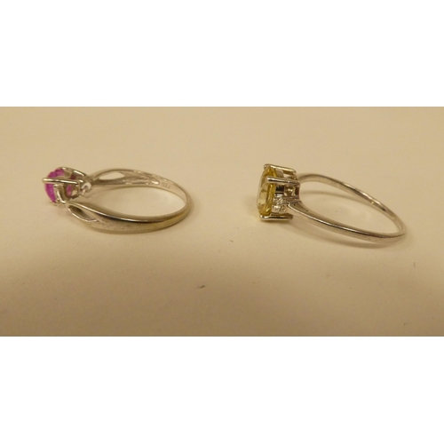 101 - Two white metal rings, one set with a yellow citrine, the other with a heart shaped pink stone