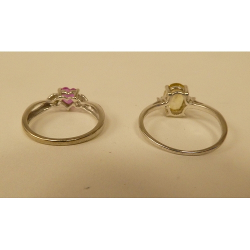 101 - Two white metal rings, one set with a yellow citrine, the other with a heart shaped pink stone