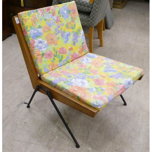 117 - A 1970s teak framed easy chair with webbing supports and splayed legs