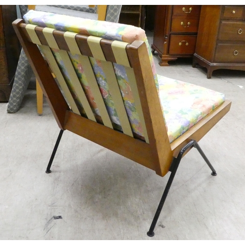 117 - A 1970s teak framed easy chair with webbing supports and splayed legs