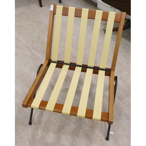 117 - A 1970s teak framed easy chair with webbing supports and splayed legs